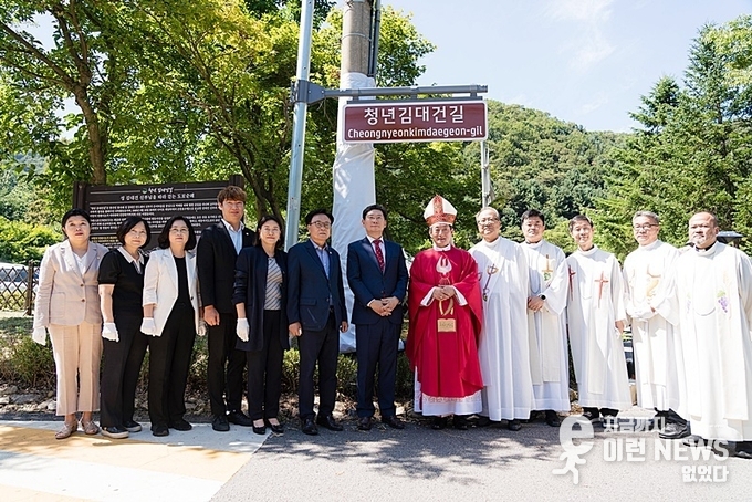 '청년 김대건 길' 명예도로 현판 아래에서 이상일 용인특례시장, 문희종 주교, 수원교구 소속 신부님 등 사제들과 기념 촬영을 하고 있다