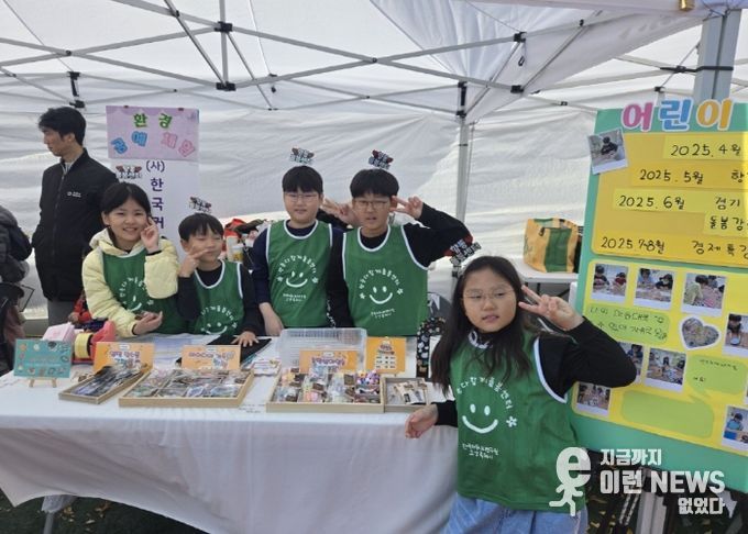 아동창업팀 수공예품 판매 부스에서 아이들이 포즈를 취하고 있다.