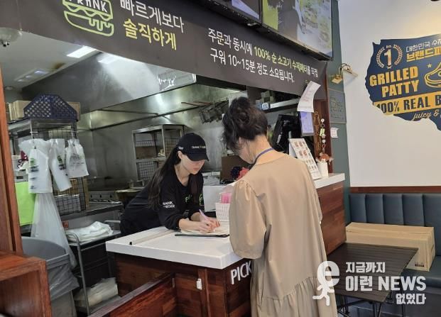 성남시 어린이 기호식품 전담관리원이 지난 9월 학교 주변 햄버거 판매점에서 영업자와 종업원의 건강진단 실시 여부를 점검하고 있다