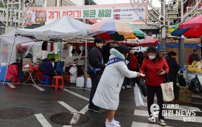 경상원이 여주한글시장을 방문한 도민들에게 '통큰 세일' 홍보물을 나눠주고 있다.